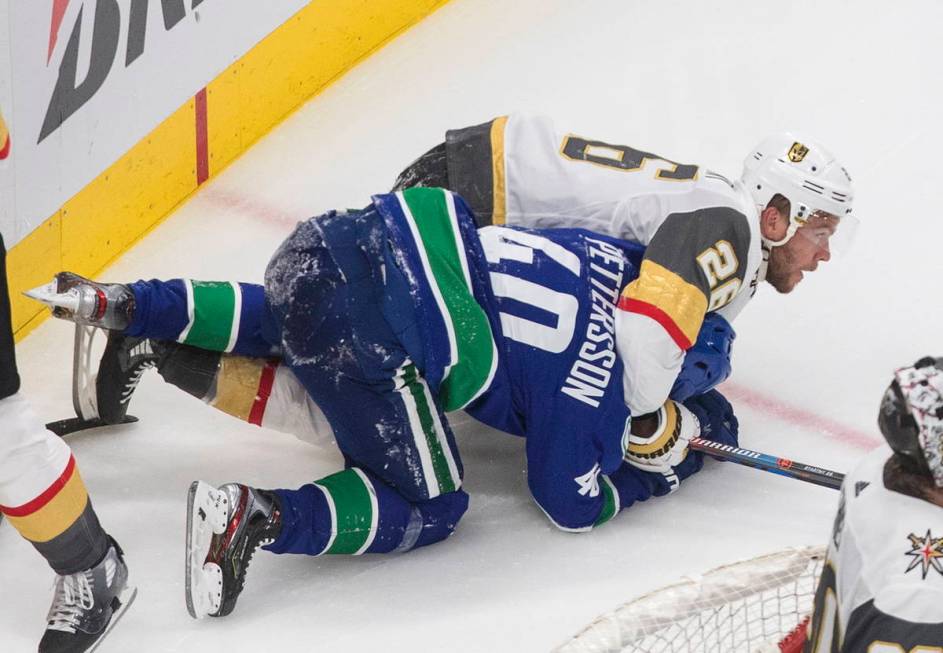 Vancouver Canucks' Elias Pettersson (40) and Vegas Golden Knights' Paul Stastny (26) rough it u ...