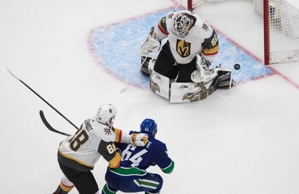 Vancouver Canucks' Tyler Motte (64) is stopped by Vegas Golden Knights goalie Robin Lehner (90) ...