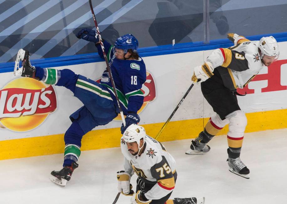 Vancouver Canucks' Jake Virtanen (18) is checked by Vegas Golden Knights' Brayden McNabb (3) du ...