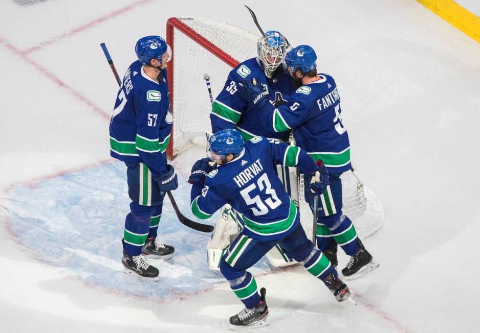 Vancouver Canucks' Tyler Myers (57), Bo Horvat (53), Oscar Fantenberg (5) and goalie Thatcher D ...