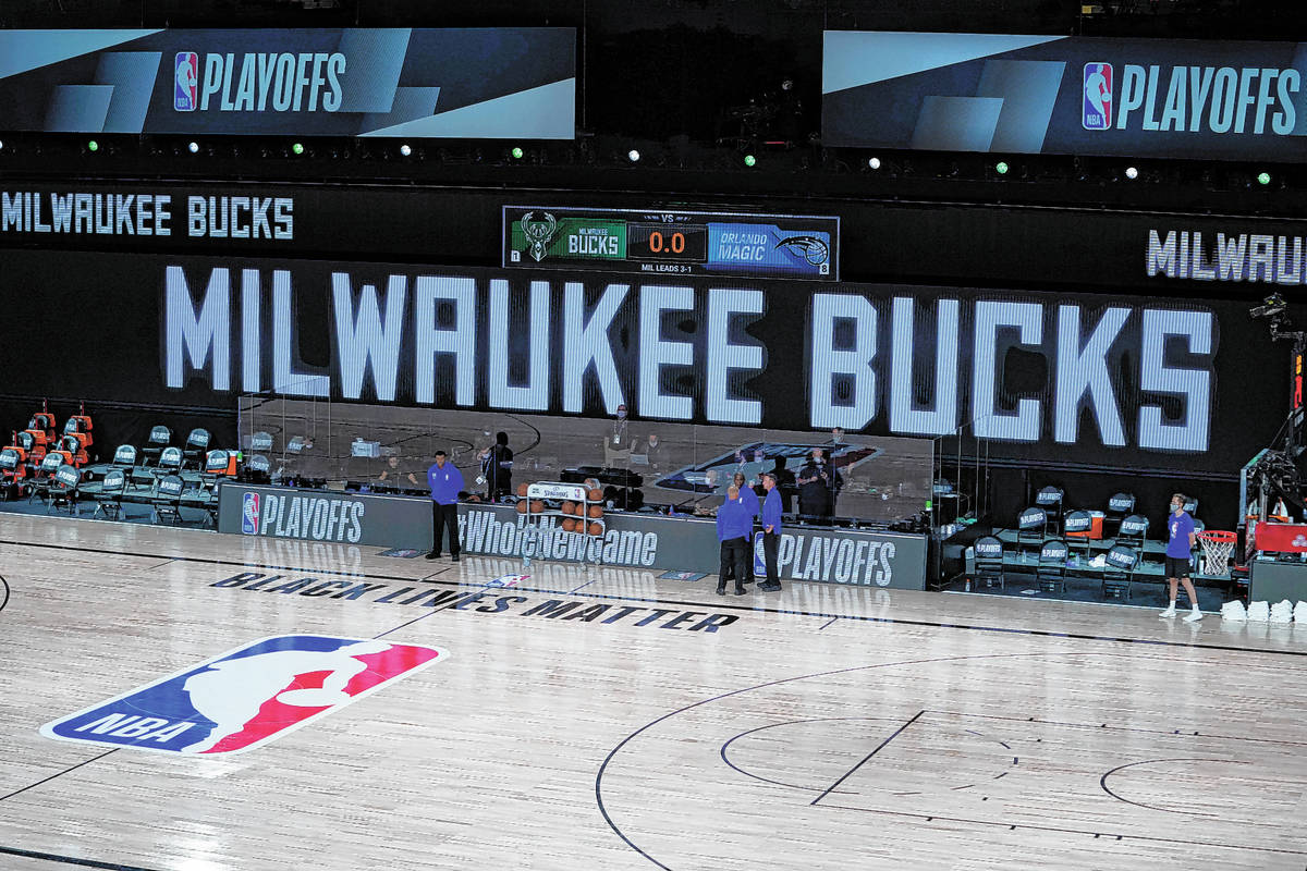 Officials stand beside an empty court at the scheduled start of an NBA basketball first round p ...