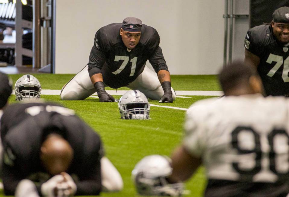 Las Vegas Raiders offensive tackle Denzelle Good (71) stretches with teammates during warm ups ...