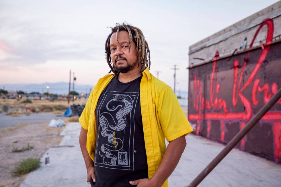 Multidisciplinary artist and community activist Brent Holmes in front of a neon-inspired artist ...