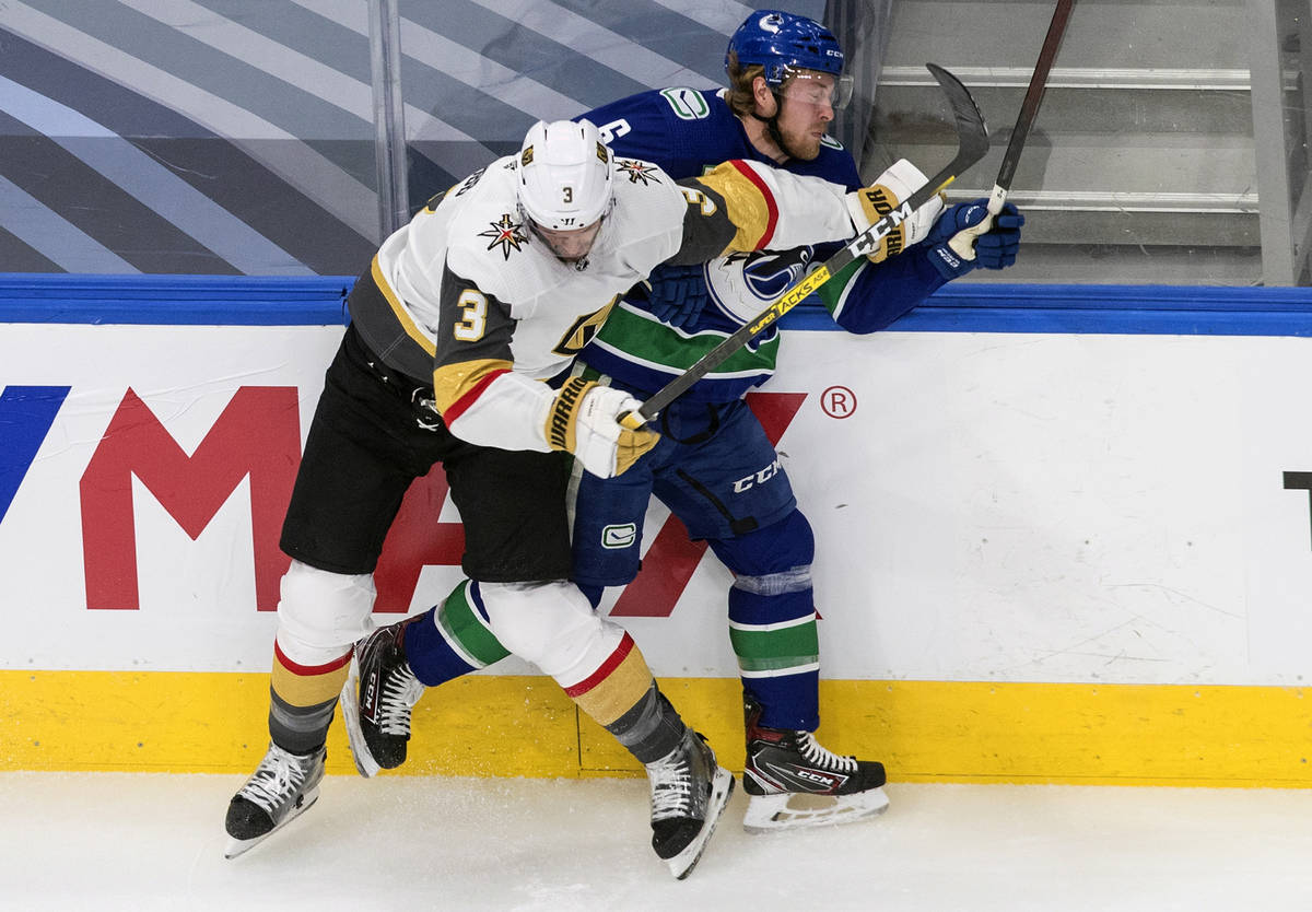 Vancouver Canucks' Brock Boeser (6) is checked by Vegas Golden Knights' Brayden McNabb (3) duri ...
