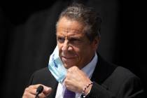 New York Gov. Andrew Cuomo removes a mask as he holds a news conference in Tarrytown, N.Y., in ...