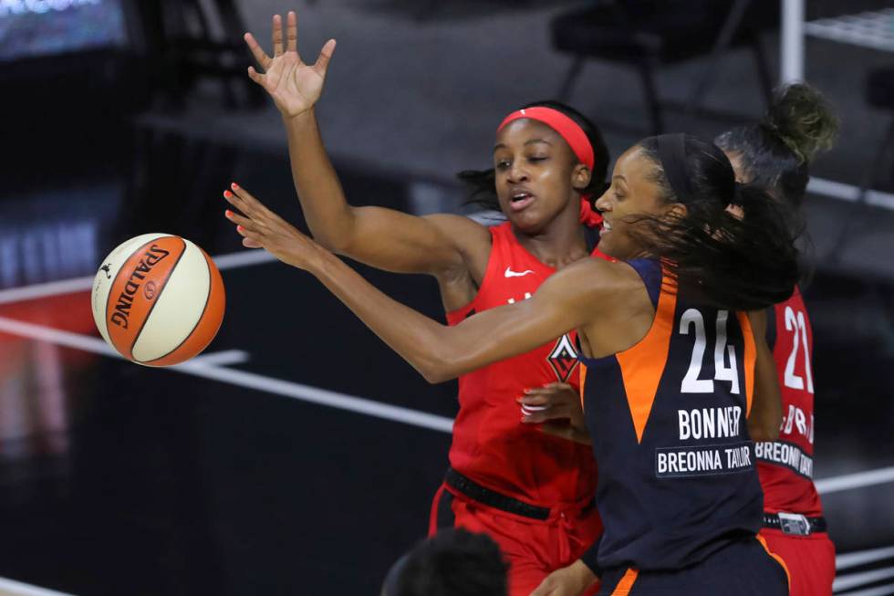 Connecticut Sun's DeWanna Bonner (24) and Las Vegas Aces' Jackie Young reach for the ball durin ...