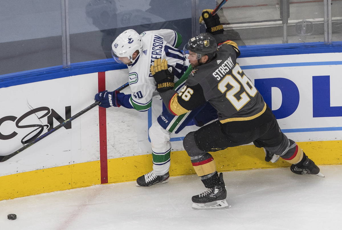 Vancouver Canucks' Elias Pettersson (40) is checked by Vegas Golden Knights' Paul Stastny (26) ...