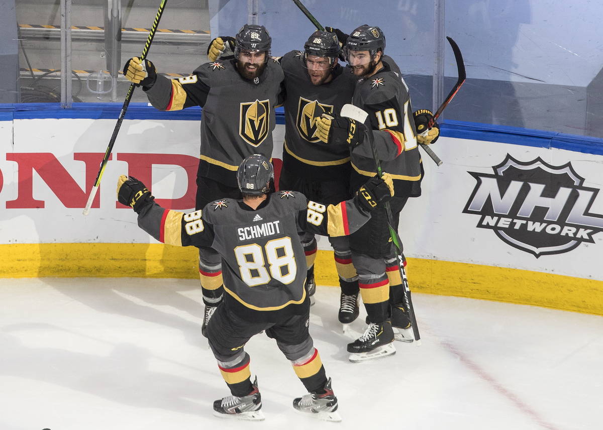 Vegas Golden Knights' Alex Tuch, left rear, celebrates his goal against the Vancouver Canucks w ...