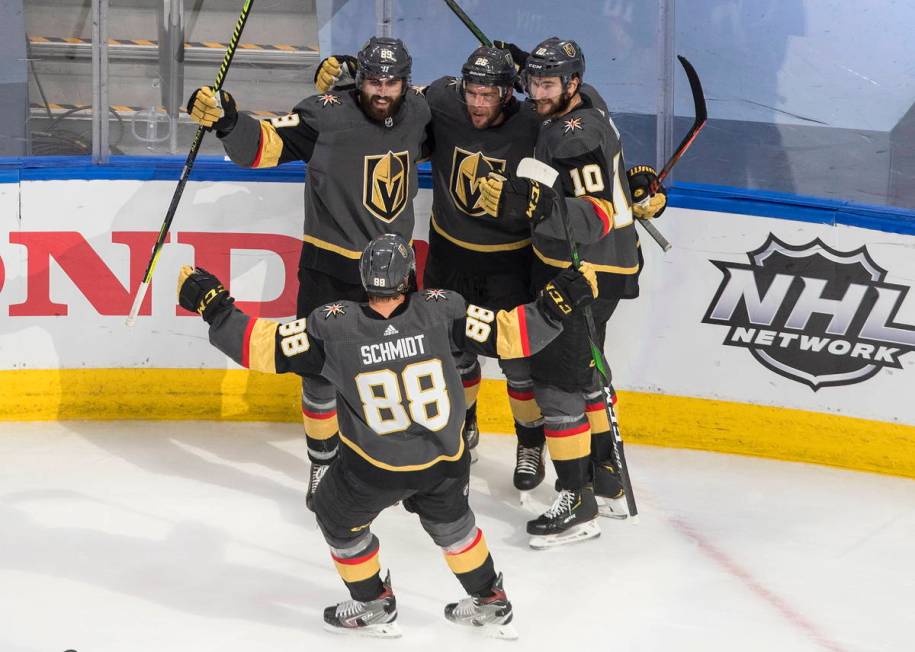 Vegas Golden Knights' Alex Tuch, left rear, celebrates his goal against the Vancouver Canucks w ...