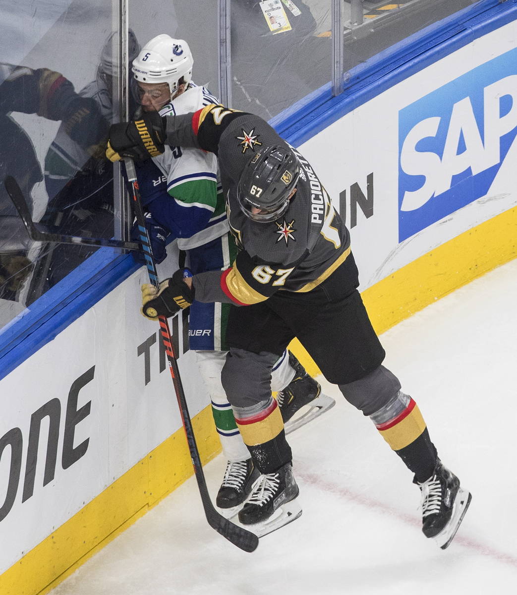 Vancouver Canucks' Oscar Fantenberg (5) is checked by Vegas Golden Knights' Max Pacioretty (67) ...