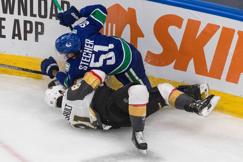 Vancouver Canucks' Troy Stecher (51) checks Vegas Golden Knights' Jonathan Marchessault (81) du ...