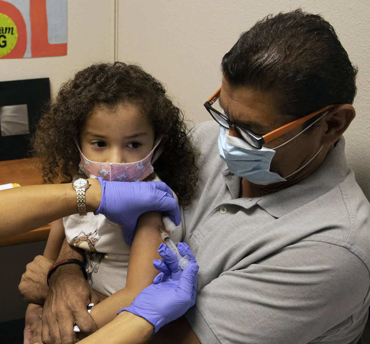Roberto Lopez holds his daughter, Jasmin Moreno, 4, as Victoria Hodge, licensed practical nurse ...