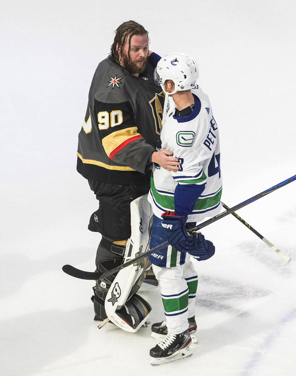Vancouver Canucks' Elias Pettersson (40) and Vegas Golden Knights goalie Robin Lehner (90) gree ...