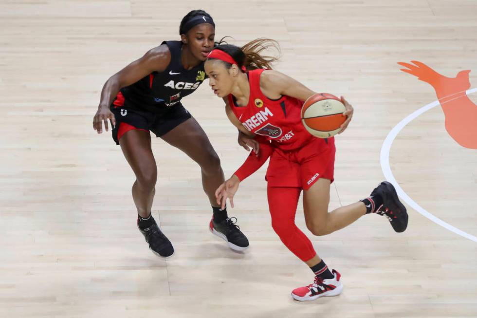 Atlanta Dream's Chennedy Carter, right, drives past Las Vegas Aces' Jackie Young during the fir ...