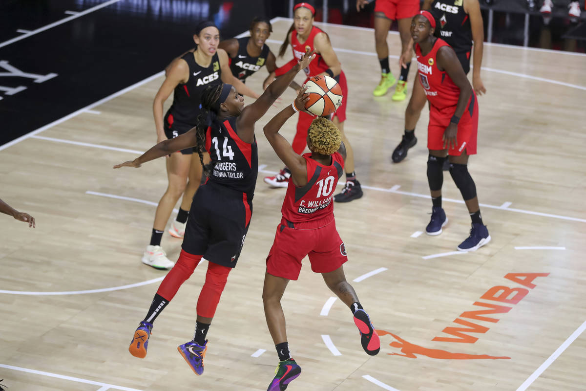 Atlanta Dream's Courtney Williams (10) shoots over Las Vegas Aces' Sugar Rodgers during the fir ...