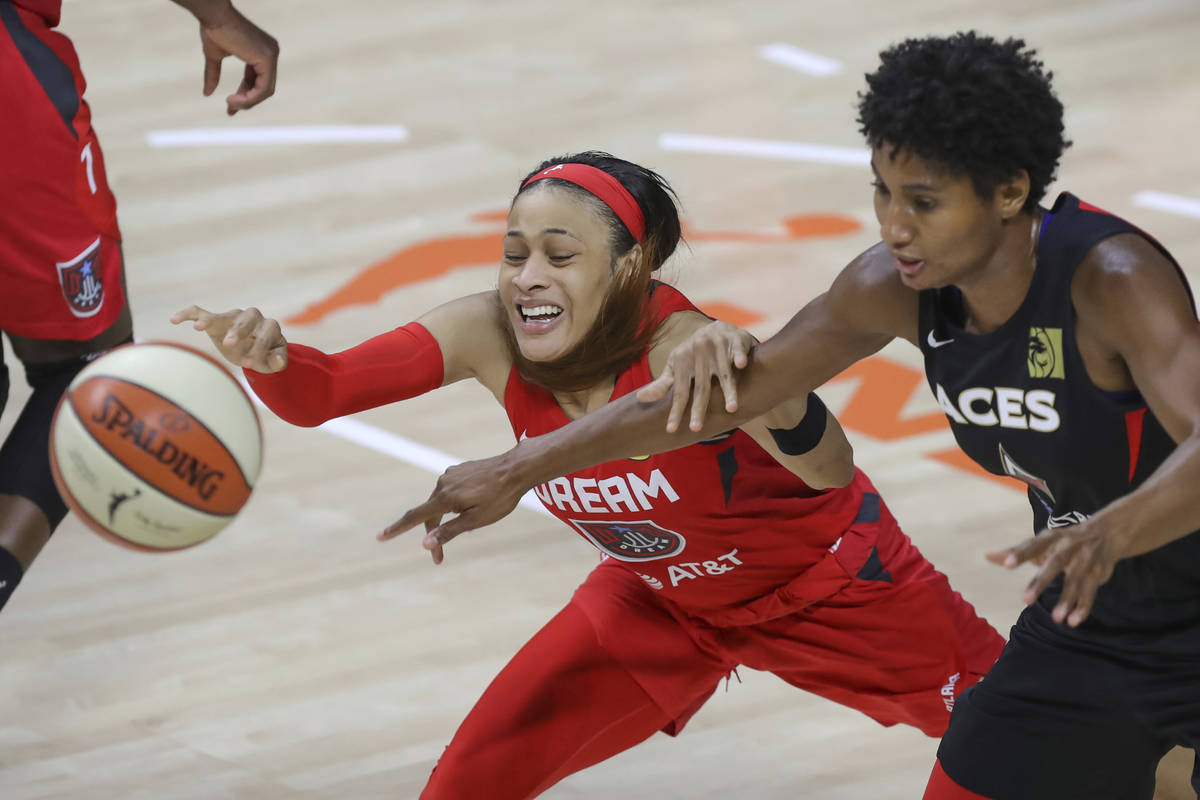 Atlanta Dream's Chennedy Carter, left, and Las Vegas Aces' Angel McCoughtry reach for the ball ...