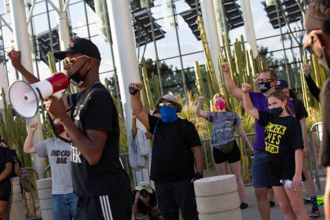 Vance "Stretch" Sanders leads chants for a group of protesters before marching at the ...