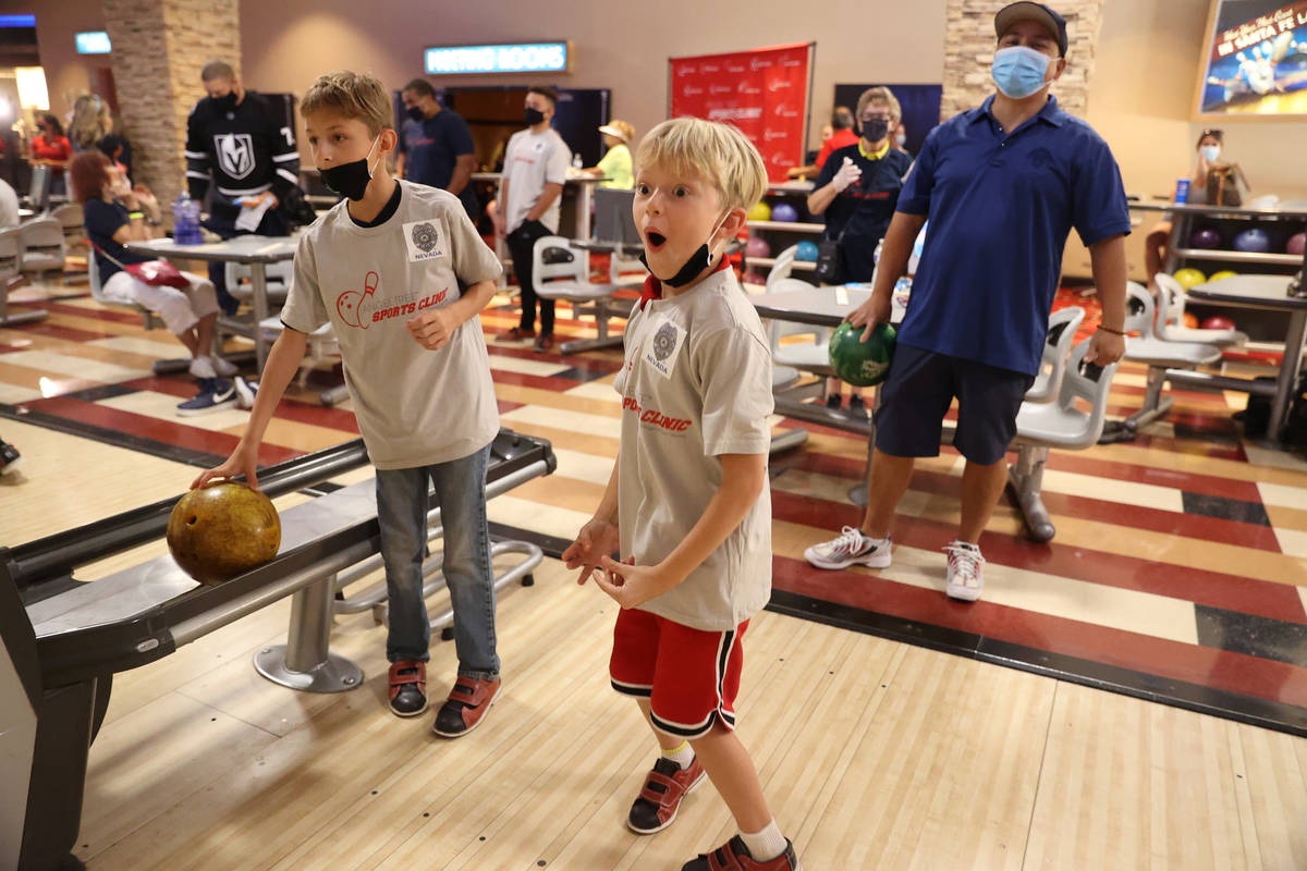 Zaidon Abramowski, 8, center, reacts after bowling, with Kenny Tibbs, 10, left, and Juan Wibowo ...