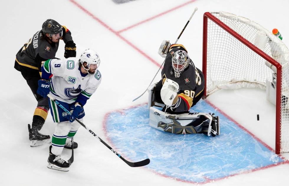 Vancouver Canucks' J.T. Miller (9) is stopped by Vegas Golden Knights goalie Robin Lehner (90) ...