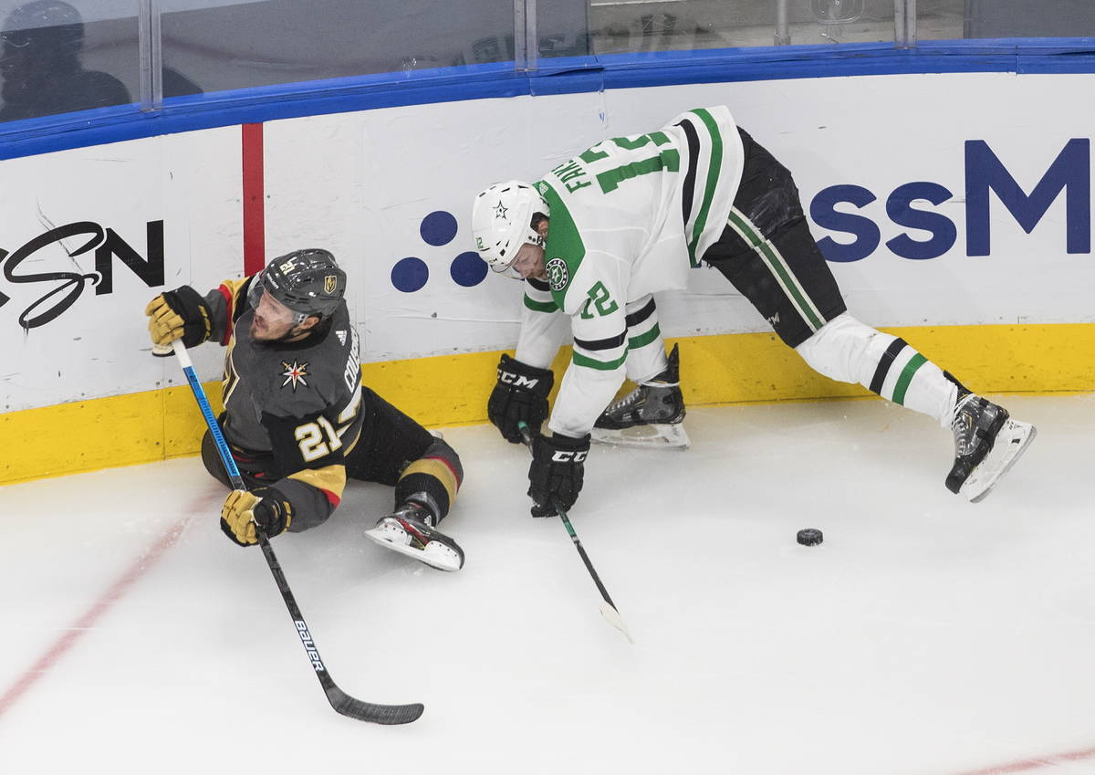 Vegas Golden Knights' Nick Cousins (21) is checked by Dallas Stars' Radek Faksa (12) during the ...