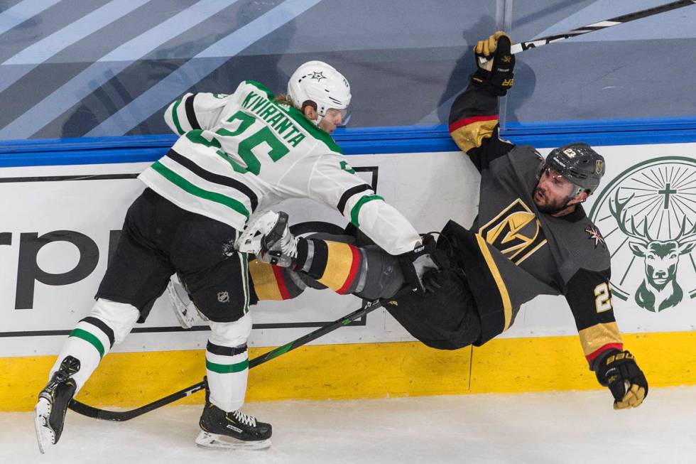 Vegas Golden Knights' Alec Martinez (23) is checked by Dallas Stars' Joel Kiviranta (25) during ...