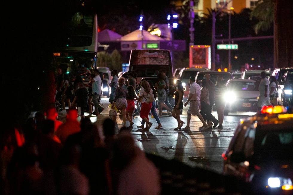 Visitors cross Las Vegas Boulevard on the Strip during Labor Day weekend on Saturday, Sept. 5, ...