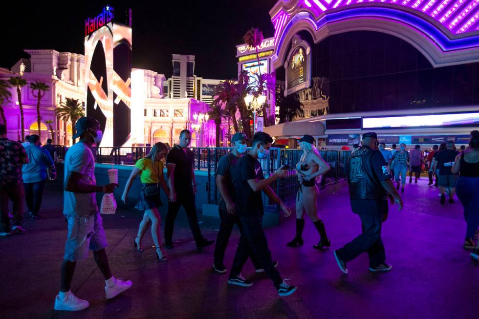 Visitors to the Strip pass by Harrah's and the LINQ during Labor Day weekend on Saturday, Sept. ...