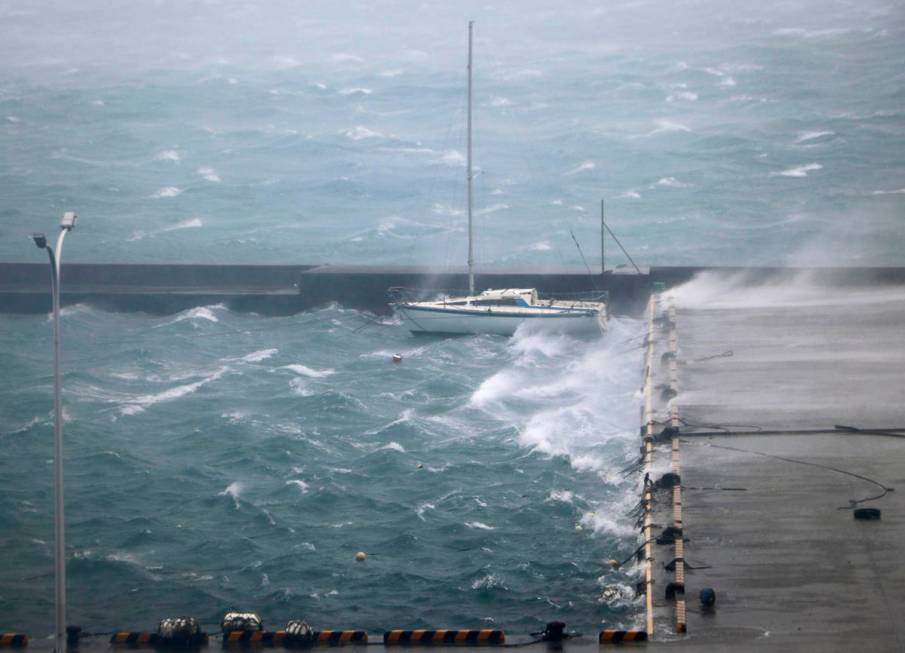 High waves pound a fishing port in Amami city, Kagoshima prefecture, southwestern Japan as a ty ...