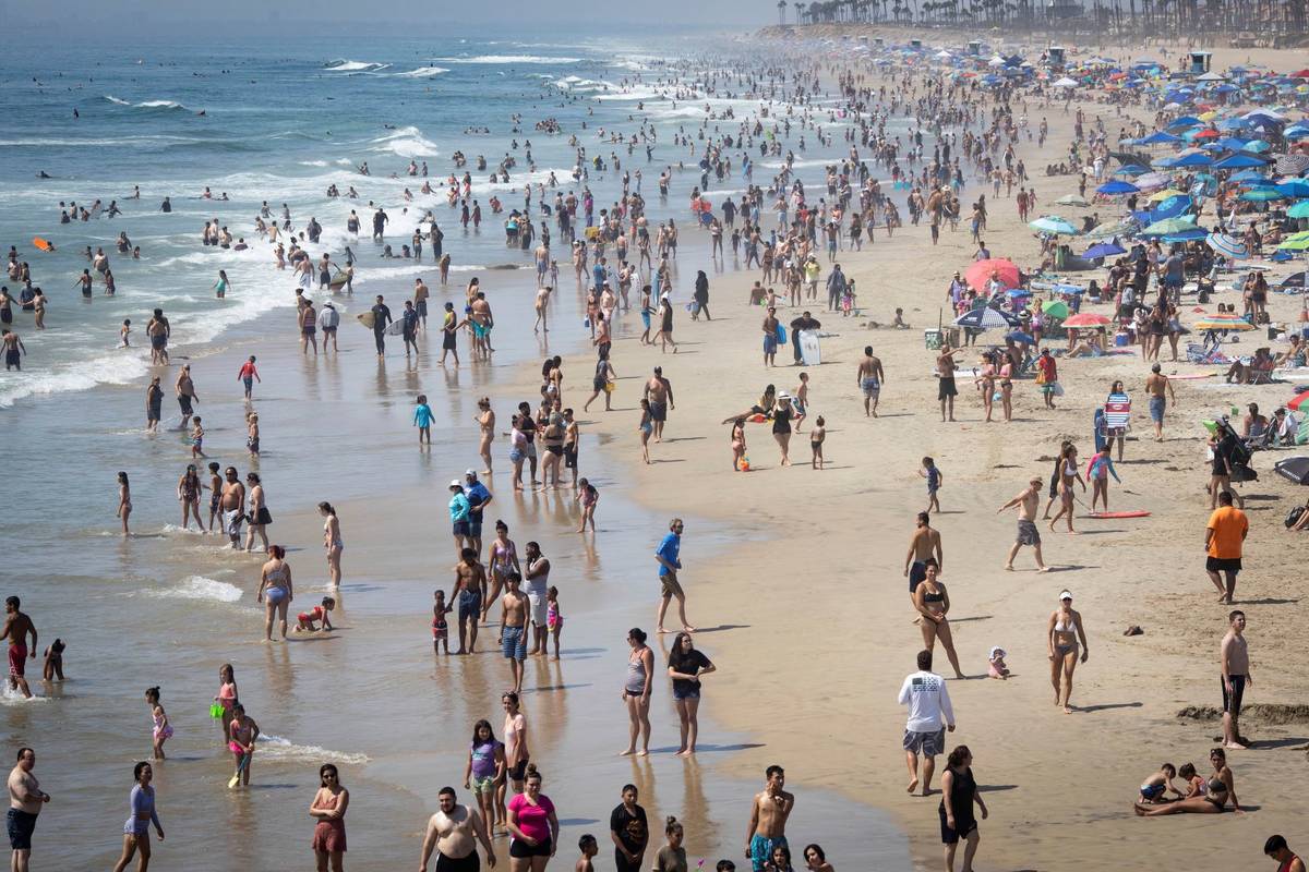 People are seen at the beach during a heat wave, Sunday, Sept. 6, 2020, in Huntington Beach, Ca ...