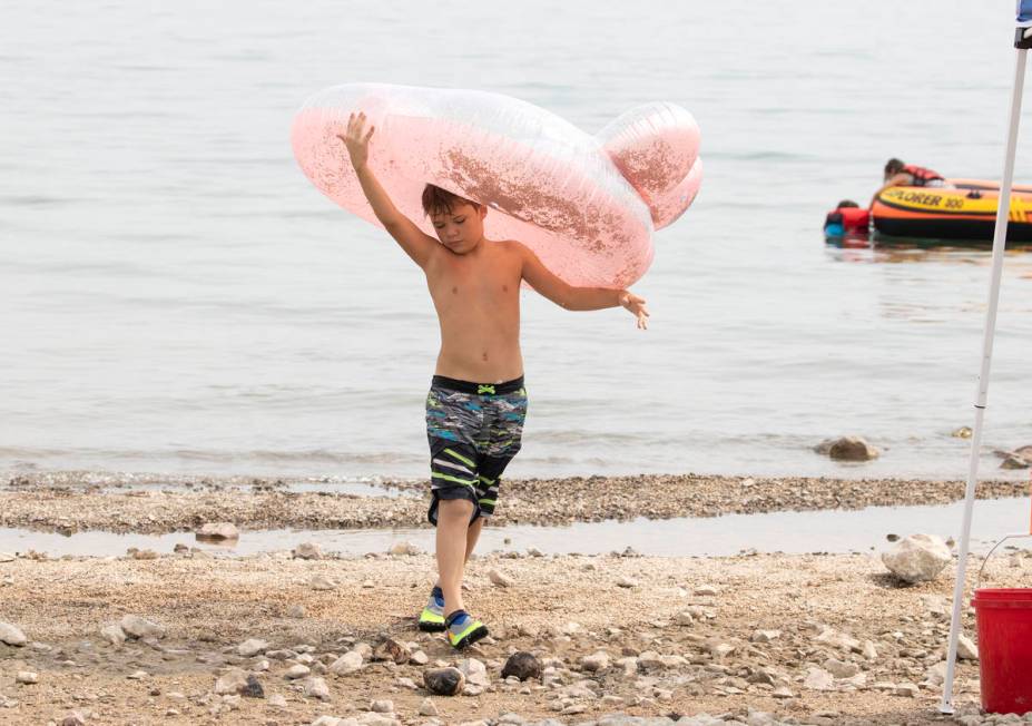 Aiden Murphy, 9, of Las Vegas carries his tube as he plays at Boulder beach in the Lake Mead Na ...