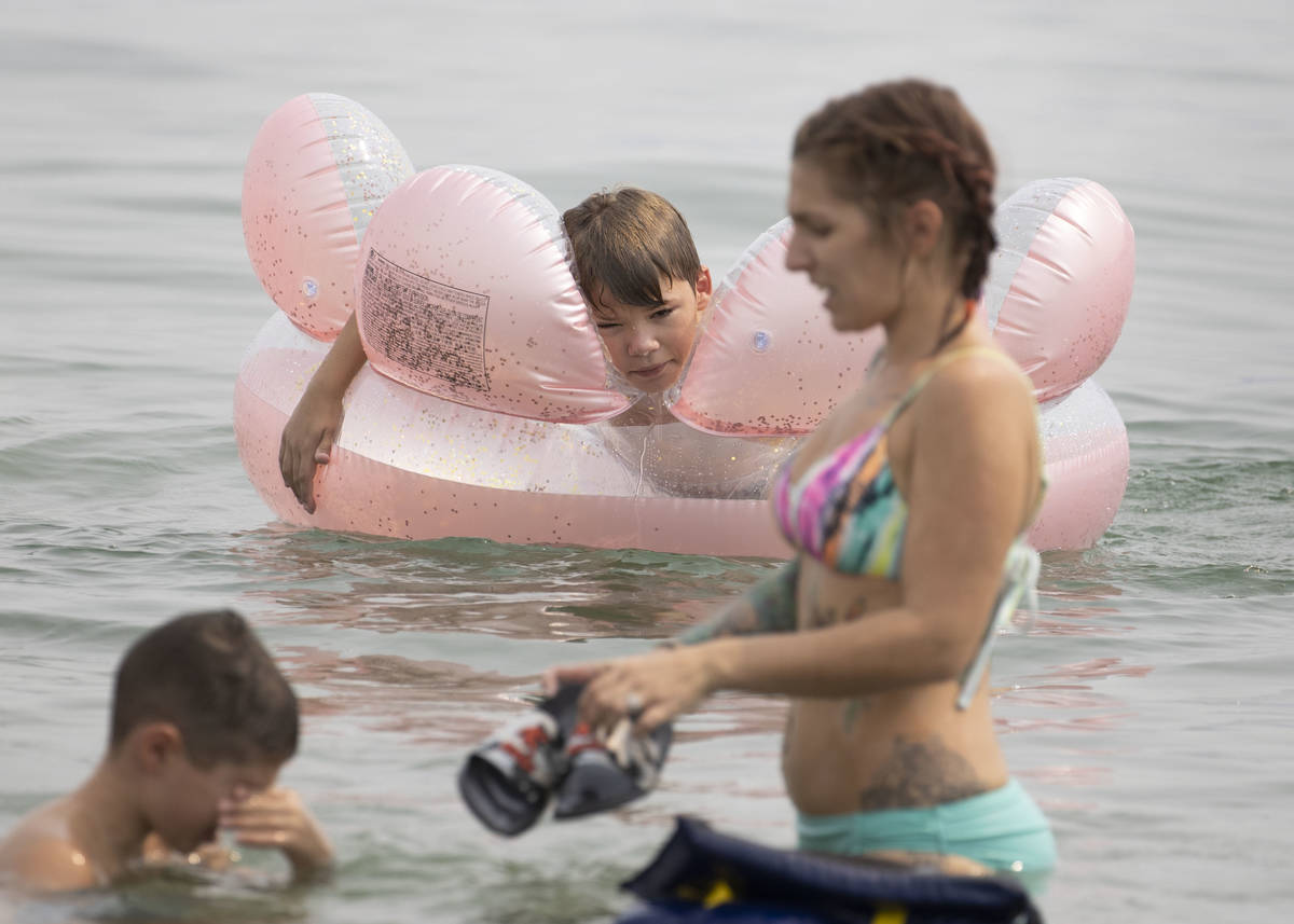 Aiden Murphy, 9, center, of Las Vegas, relaxes at Boulder beach in the Lake Mead National Recre ...