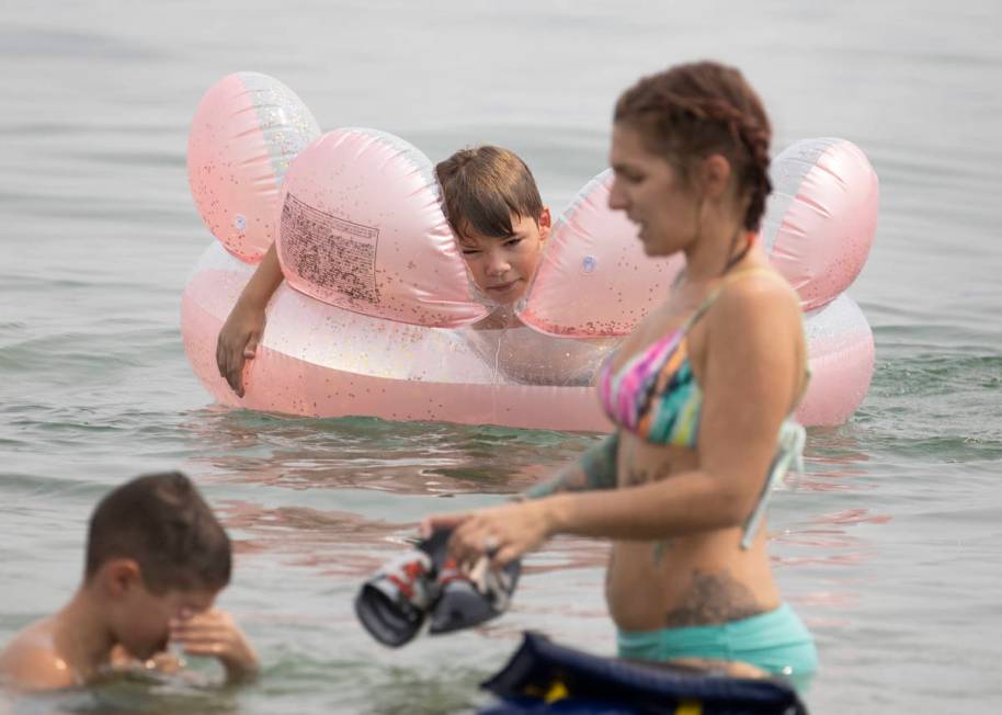 Aiden Murphy, 9, center, of Las Vegas, relaxes at Boulder beach in the Lake Mead National Recre ...