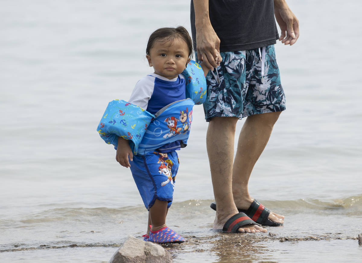 Keanu Guzman, 1, walks with father James along Boulder beach in the Lake Mead National Recreati ...