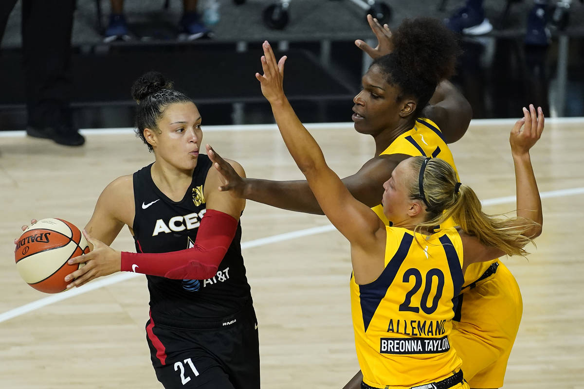 Las Vegas Aces guard Kayla McBride (21) gets stopped by Indiana Fever guard Julie Allemand (20) ...