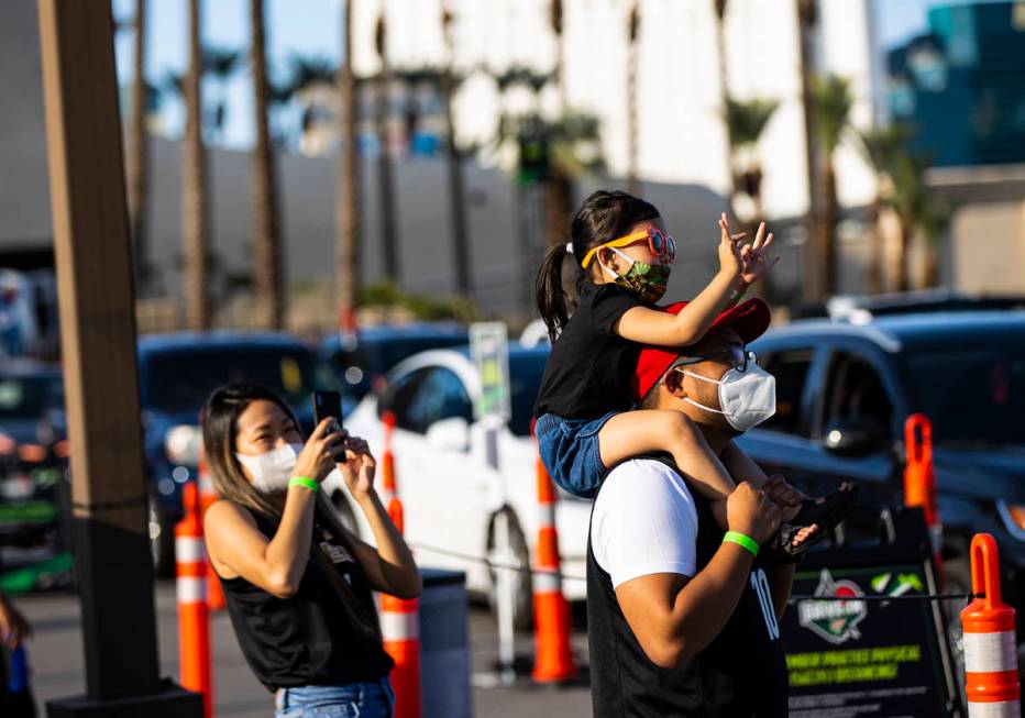 Las Vegas Aces fan Kris Gabriel, left, takes a photo of Aubrey Gabriel, 3, held by Armand Reyes ...