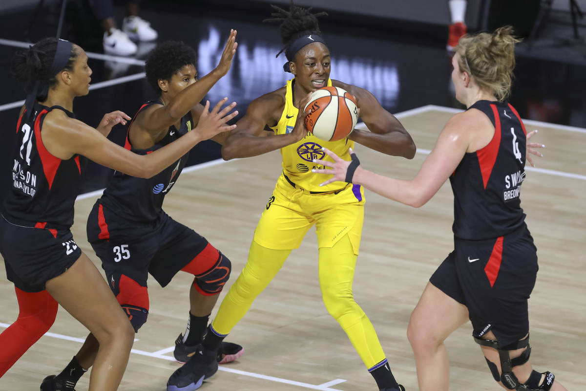Los Angeles Sparks' Nneka Ogwumike is surrounded by the defense of Las Vegas Aces' A'ja Wilson ...