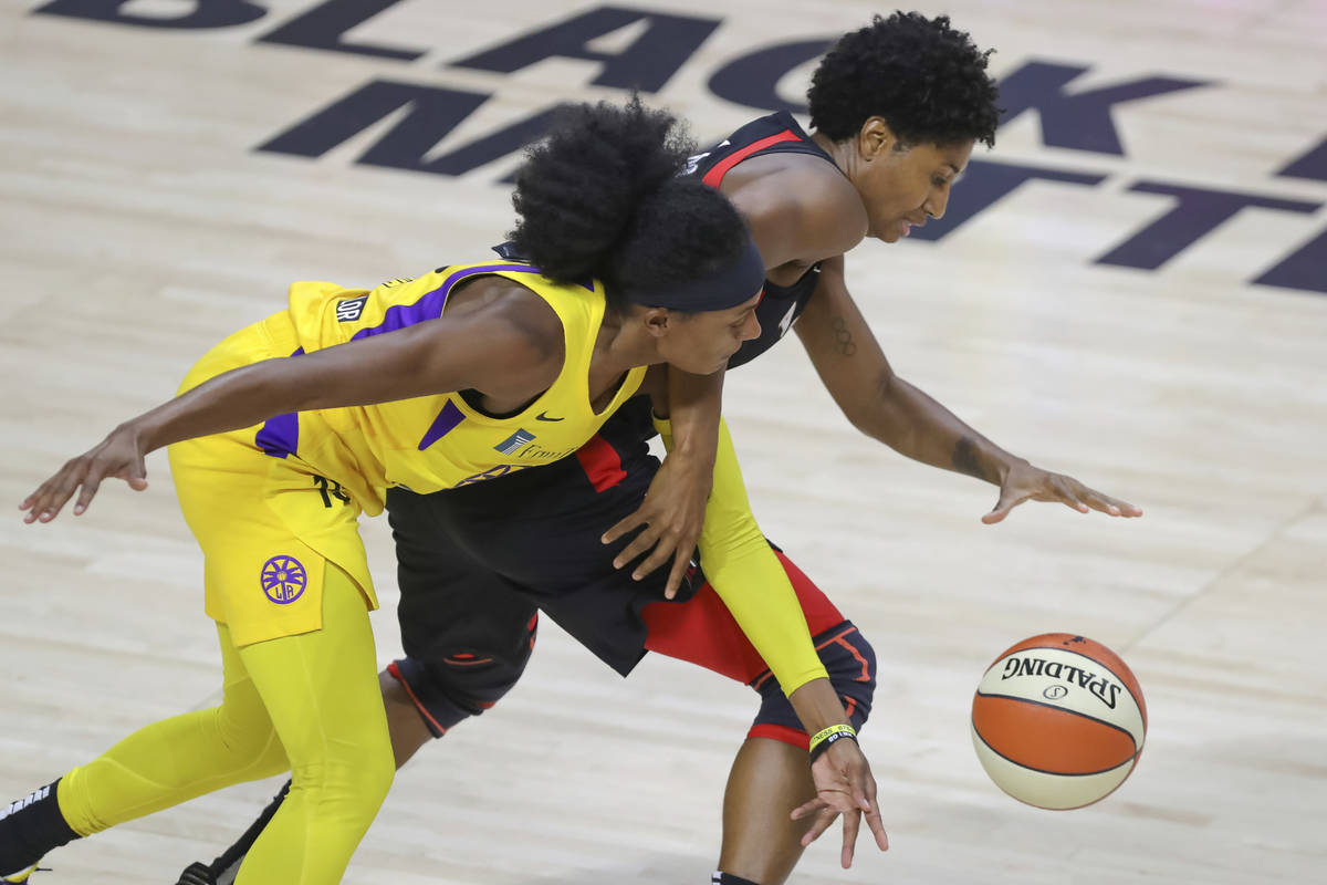 Los Angeles Sparks' Brittney Sykes, left, reaches in against Las Vegas Aces' Angel McCoughtry d ...