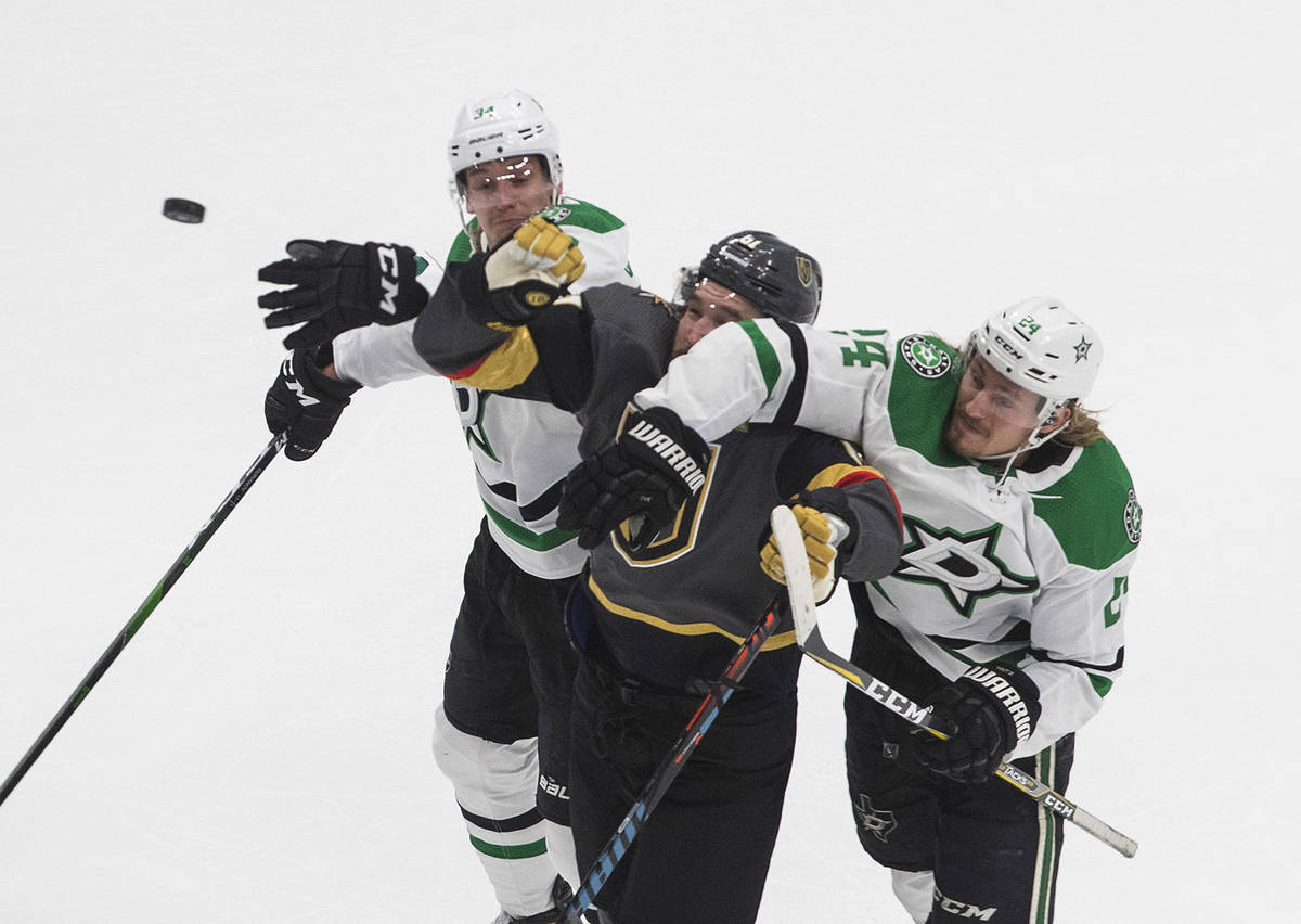 Dallas Stars' Denis Gurianov (34) and Roope Hintz (24) compete for the puck with Vegas Golden K ...