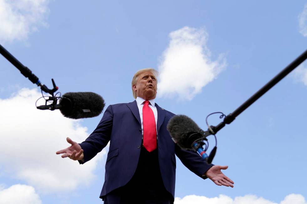 President Donald Trump speaks to reporters before boarding Air Force One for a trip to Jupiter, ...