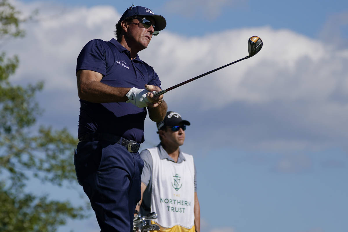 Phil Mickelson watches his tee shot on the 17th hole in the first round of the Northern Tr ...