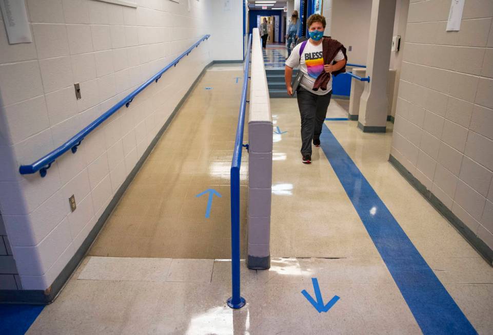 A student walks through the halls of Carlton High School on Tuesday while following the marked ...