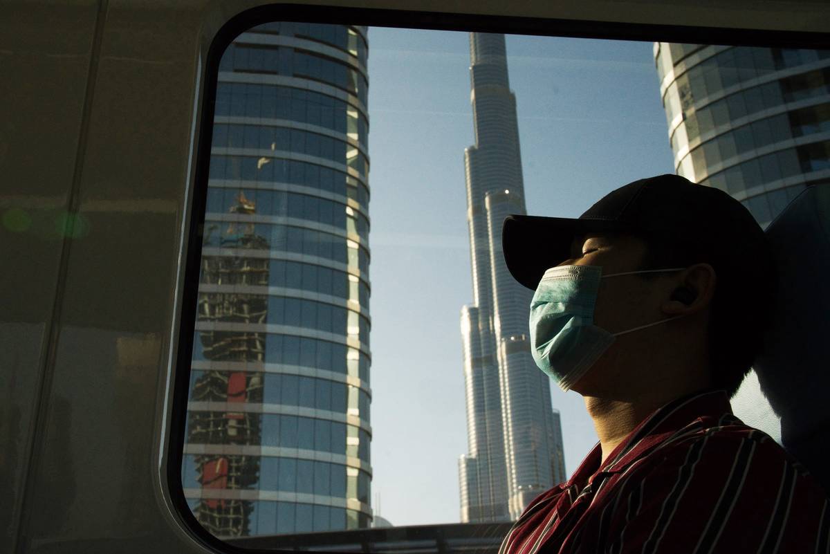 FILE - In this April 26, 2020 file photo, a commuter wearing a face mask to help curb the sprea ...
