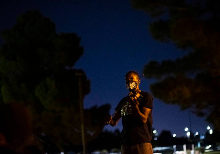 Violinist Brandon Summers performs during a candlelight vigil for Jorge Gomez and others who ha ...