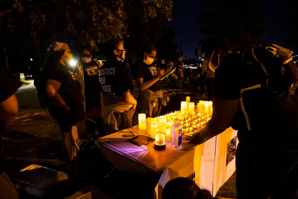 People gather at a candlelight vigil for Jorge Gomez and others who have died from police viole ...