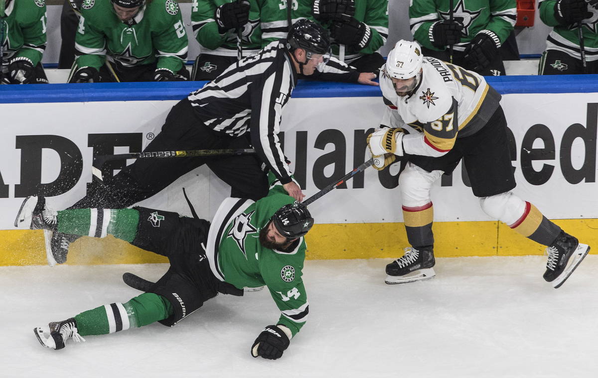 Dallas Stars left wing Jamie Benn (14) is checked by Vegas Golden Knights left wing Max Paciore ...
