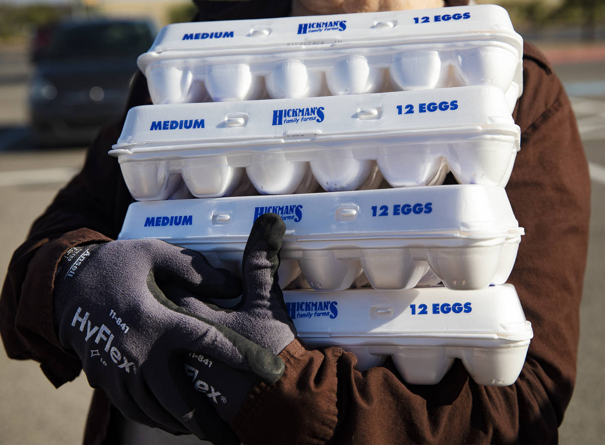 Volunteer Christina Bailey holds packs of eggs to be given away at the new drive-thru distribut ...