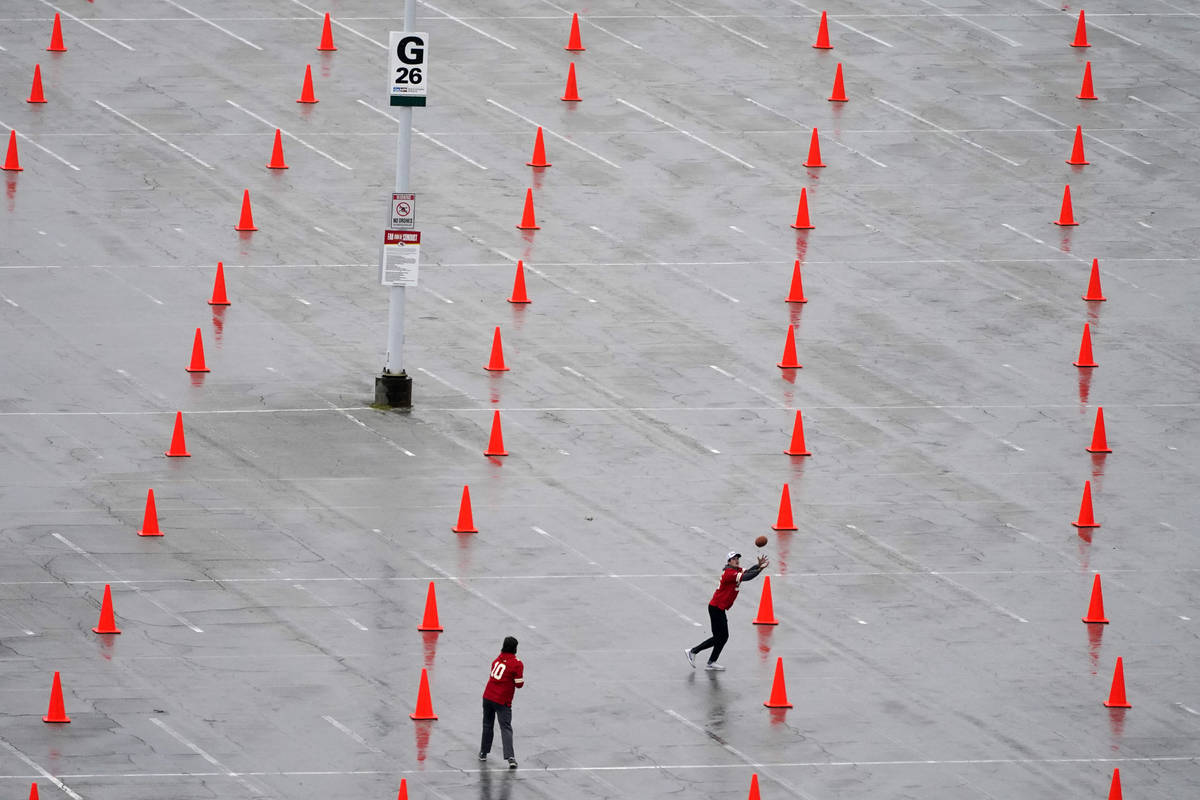 Fans throw a football outside Arrowhead Stadium before an NFL football game between the Kansas ...