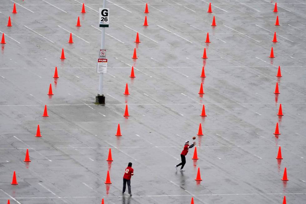 Fans throw a football outside Arrowhead Stadium before an NFL football game between the Kansas ...