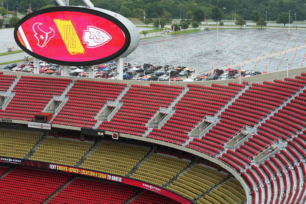Cars are parked in a mostly empty parking lot at Arrowhead Stadium before an NFL football game ...