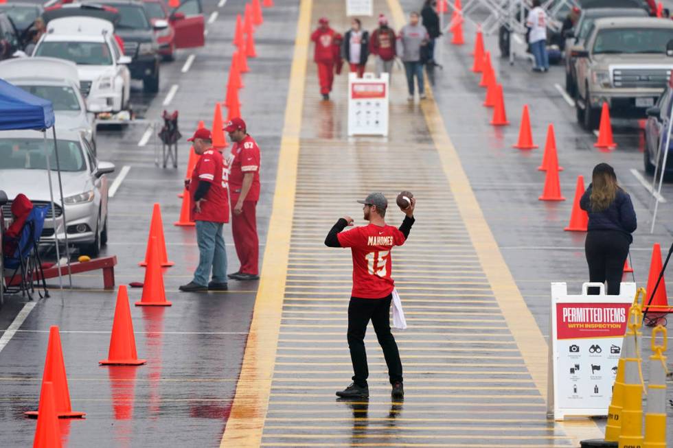 A fan throws a football outside Arrowhead Stadium before an NFL football game between the Kansa ...